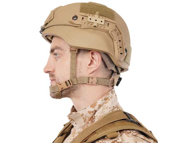 Side view of a man wearing a tan mid-cut tactical helmet with side rails, chin strap, and camouflage uniform.