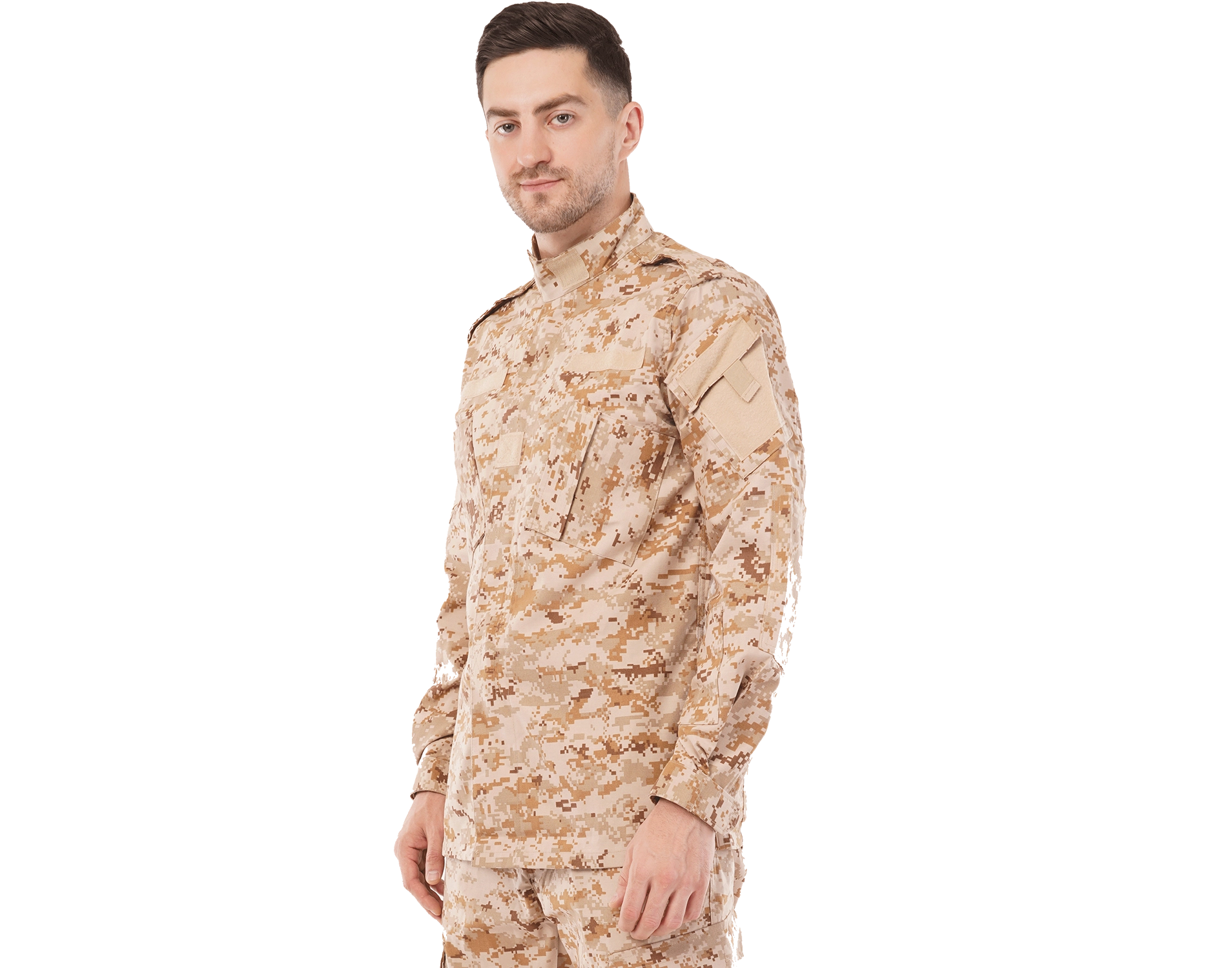Man wearing a desert camouflage tactical uniform, standing angled to the side with a neutral expression against a light background.
